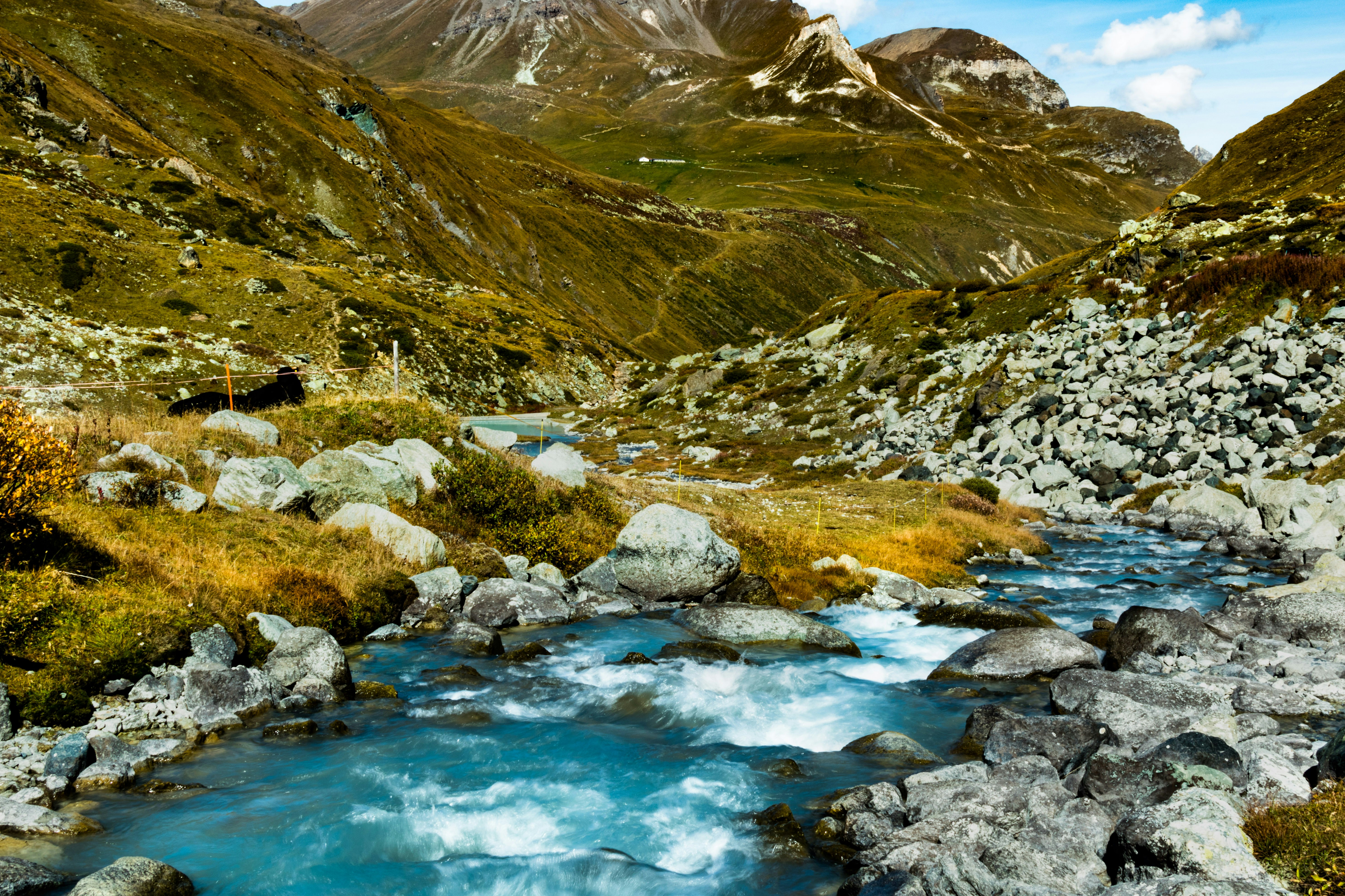 green and brown mountains beside river during daytime